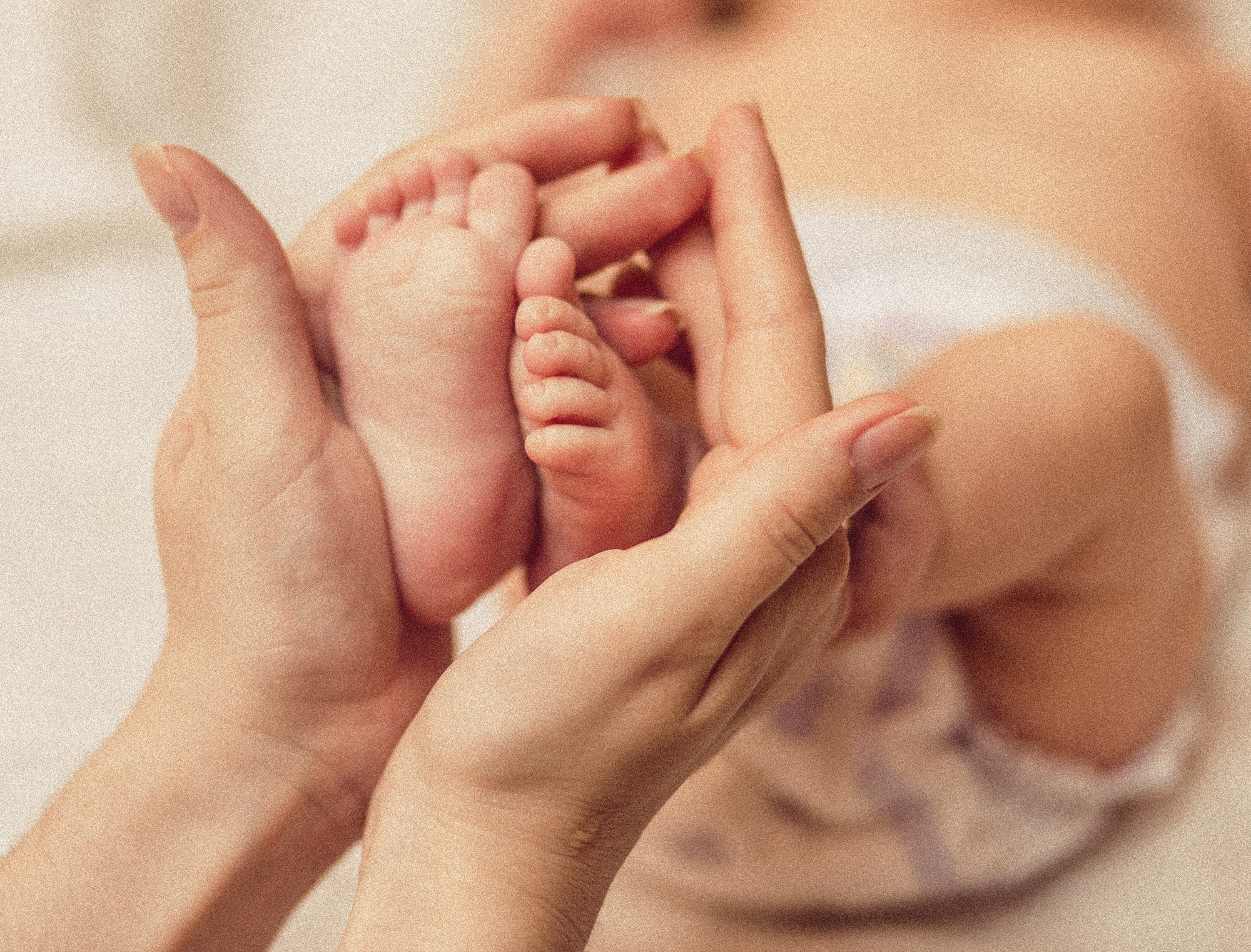 Hebamme Frauenhände halten die Füße von einem Neugeborenen Baby in der Hand